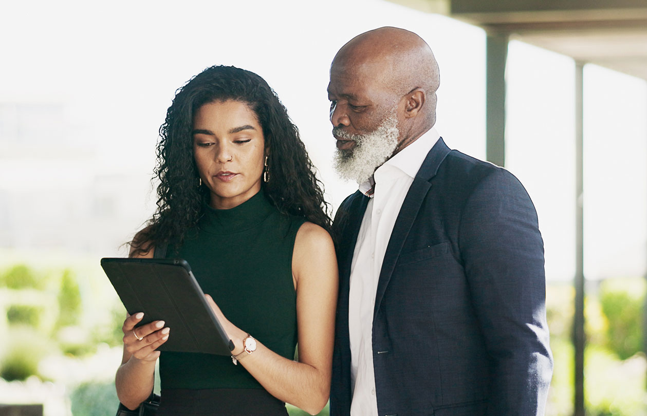 A business man and woman looking at a suspcious email on a tablet device.