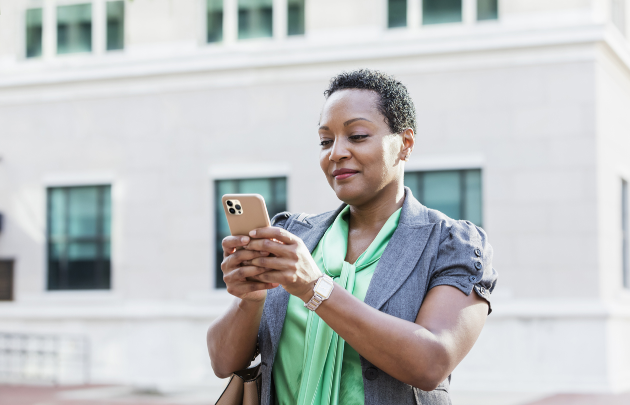 A smiling woman texting on her mobile phone